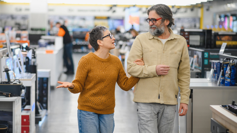 Two people talking as they walk through an appliance store