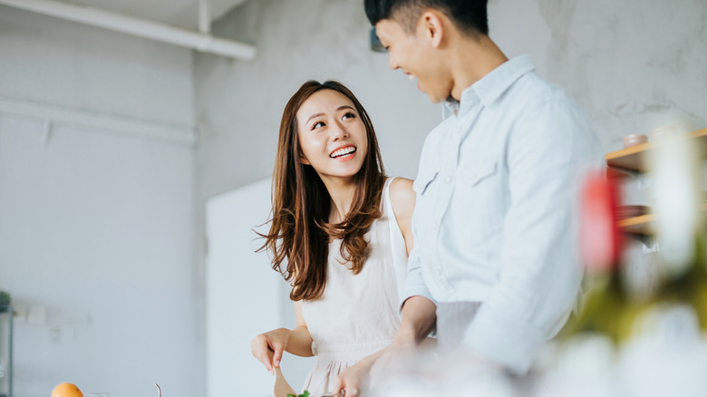 A couple in a Japanese kitchen prepares food.