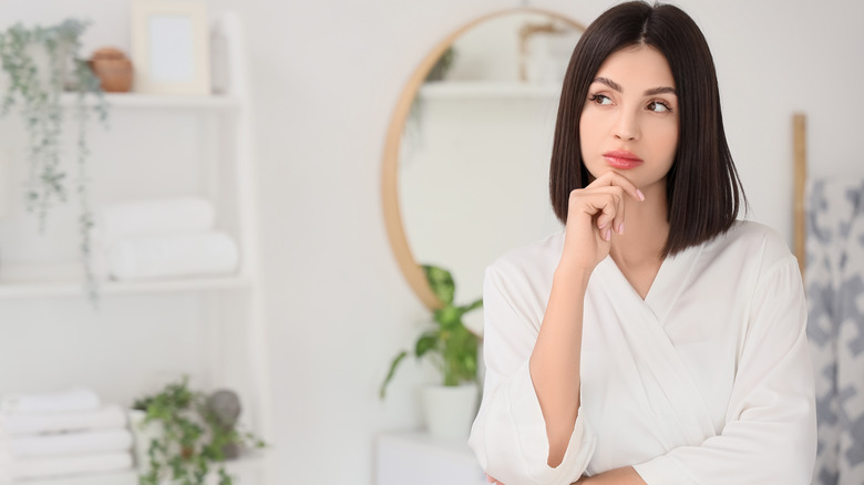 A woman thinking in the bathroom