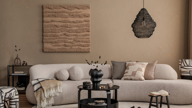 A modern, minimalist living room with walls painted in a soft brown shade