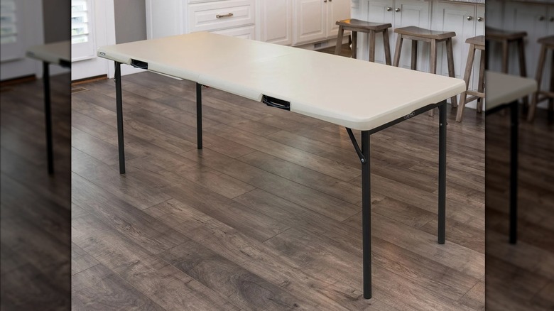 A large portable Lifetime table sits on a hardwood floor in a neutral kitchen