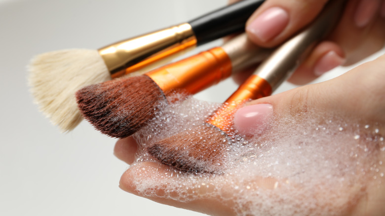 Hand cleaning dirty makeup brushes with detergent