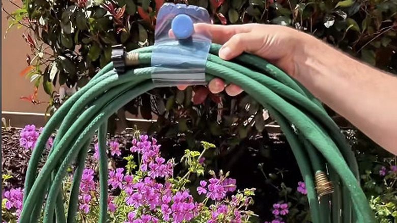 Garden hose loop formed by plastic water bottle
