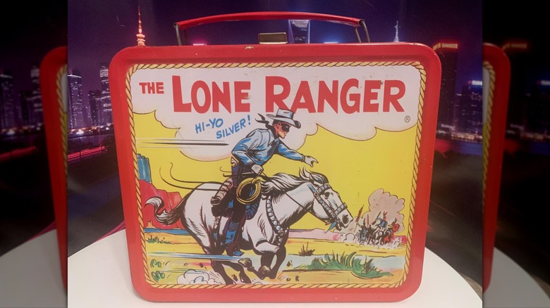 A vintage "Lone Ranger" lunchbox sits on a white table