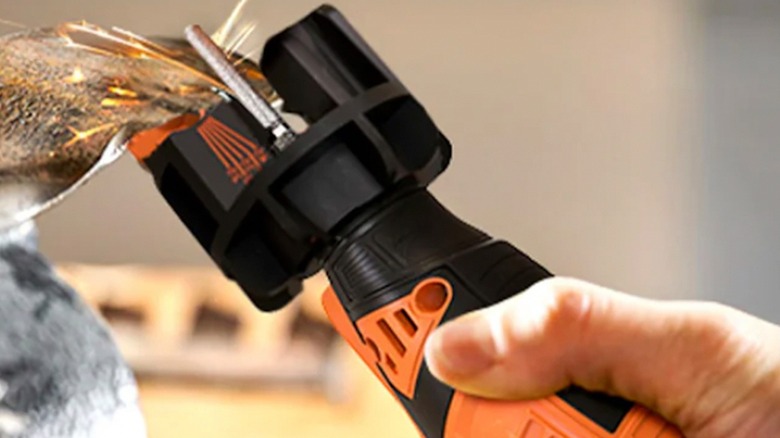 Person using Sharp Pebble tool to sharpen a lawnmower blade
