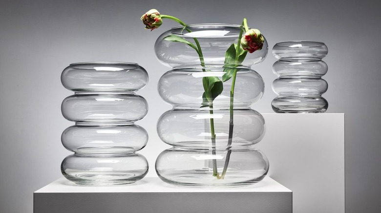 Two flower buds are displayed in collection of glass blown vases