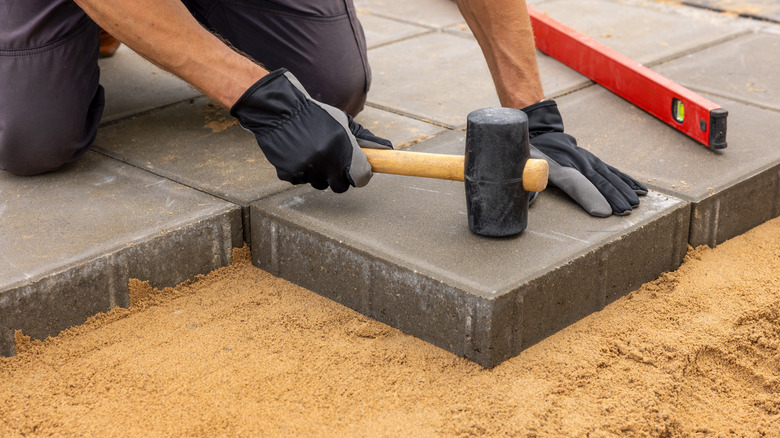a worker leveling a paver