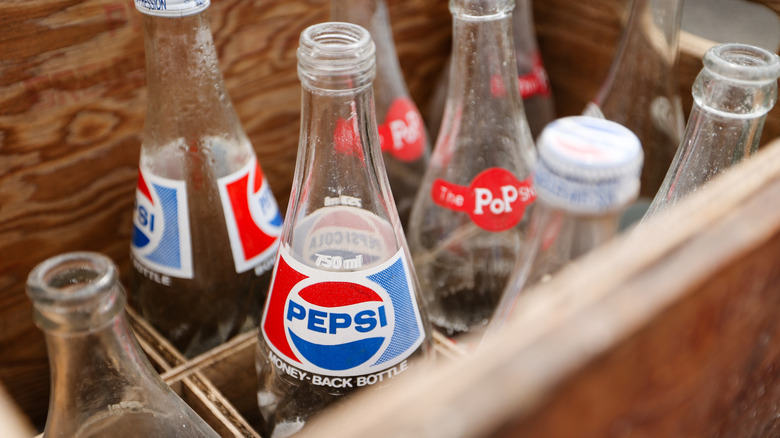 Vintage Pepsi bottles in a wooden crate