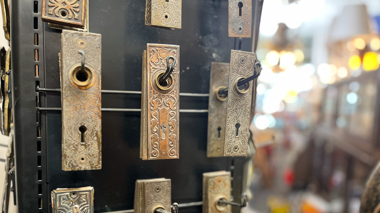 Vintage door hardware hanging on a spinning rack at an architectural salvage store