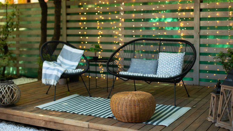 A backyard woodscaping project including a fence and patio with outdoor furniture on it