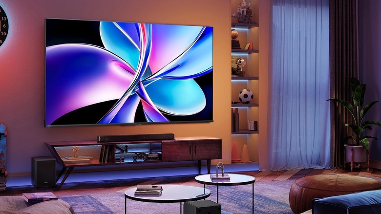 A large Hisense smart TV is installed on the wall of a living room