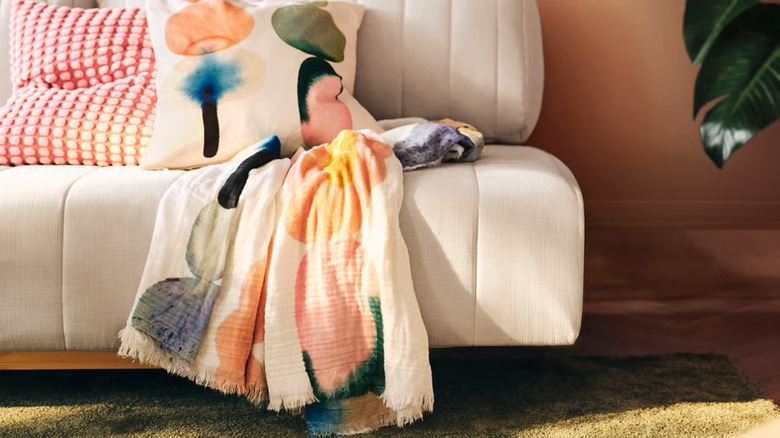A thin, colorful IKEA throw on a white sofa
