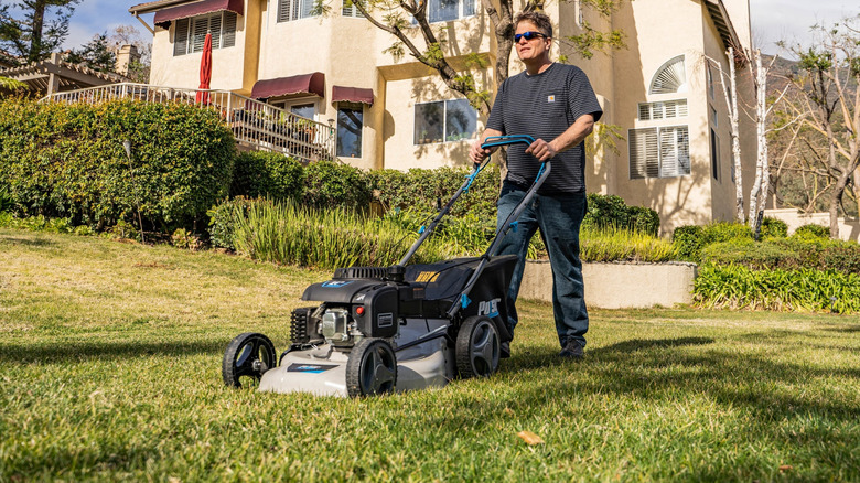 A man mowing his lawn with the 00cc Pulsar self-propelled mower