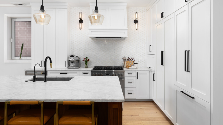 White kitchen with warm light and quartz countertop island