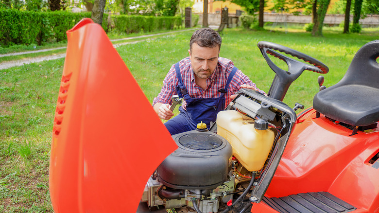 person working on lawn mower
