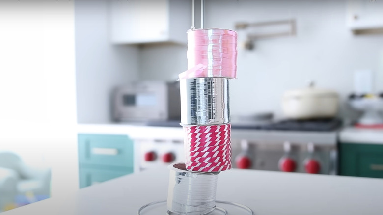 Several rolls of wrapping paper ribbon stacked on a paper towel holder.