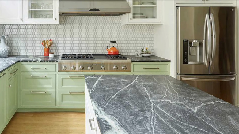Gray soapstone countertop in a kitchen with green cabinetry