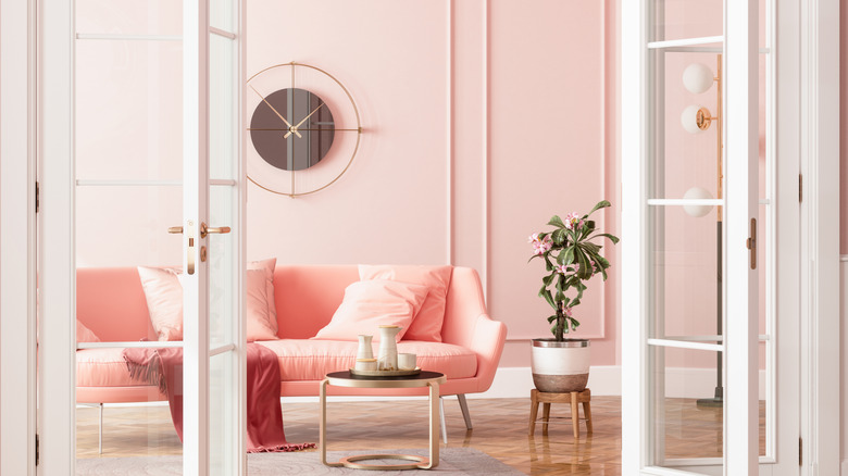 A soft and warm-toned pink living room with lots of natural light