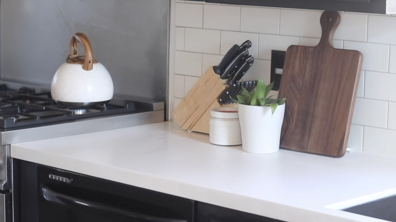 White solid surface countertop next to a stove