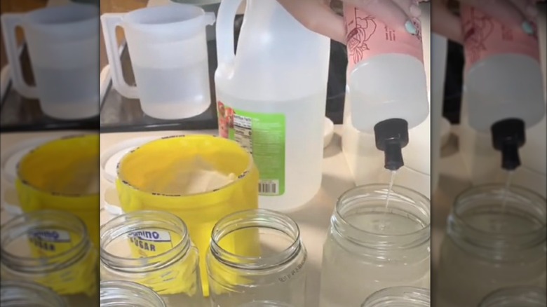 pouring dish soap into pickle jar
