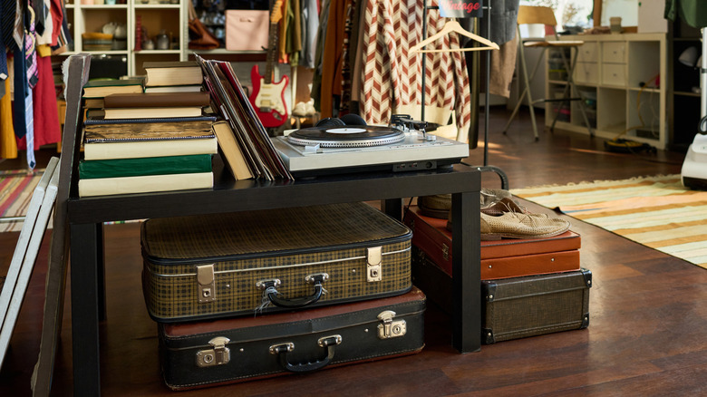 Vintage suitcases sit on the floor of a thrift store
