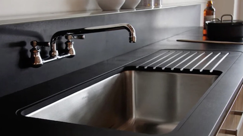 Black Paperstone countertop surrounding a sink shows off its sleek look.
