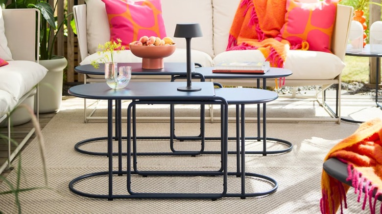 Two GRYTSHOLM Nesting Tables set up in front of an outdoor couch
