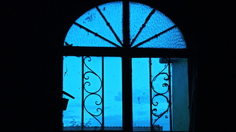 Faint blue light emanating from an old-style window
