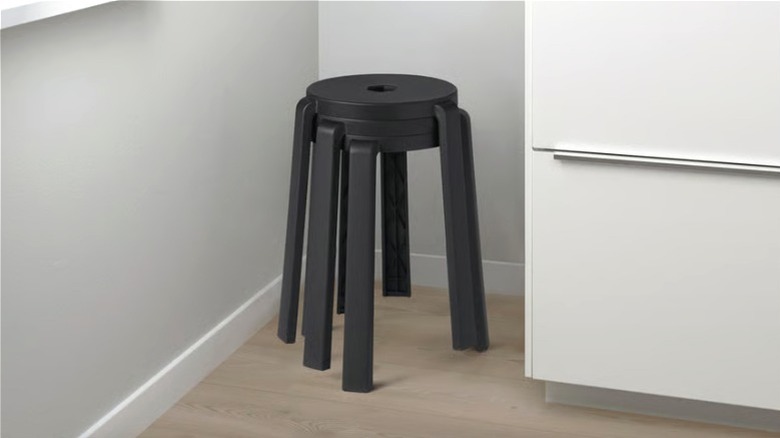 Three black IBBARBO stools stacked in a corner