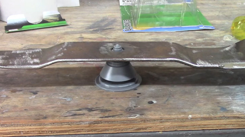 Checking the balance of a mower blade with the Arnold sharpening and balancing kit
