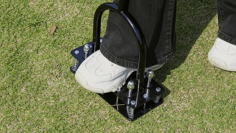 Person using the RIFPOD Manual Lawn Aerator Tool on their lawn