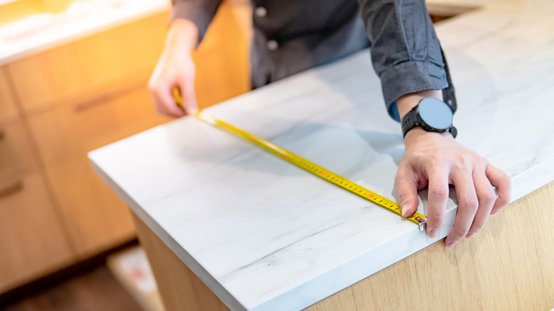 Worker measuring countertops for installation
