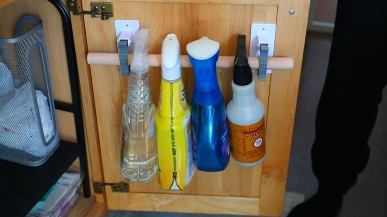 Cleaning products hung on cabinet door using Dollar Tree DIY
