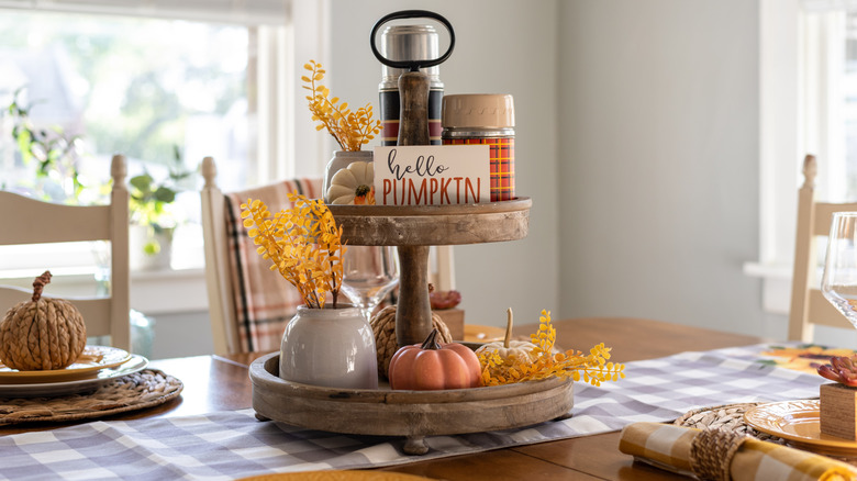 A collection of home decor items is organized on a vintage wooden tiered tray