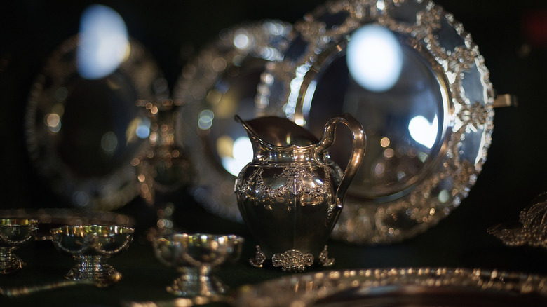 Tiffany silver serving pitcher and plates on display