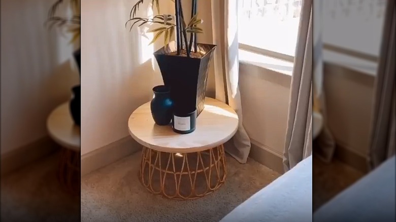 Small table in the corner made from an upside-down IKEA basket and a wood round
