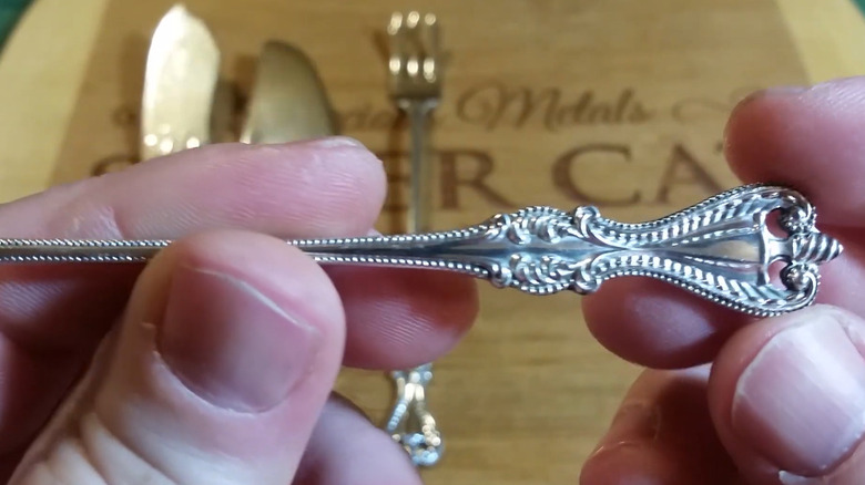 Person holding a Towle silverware piece