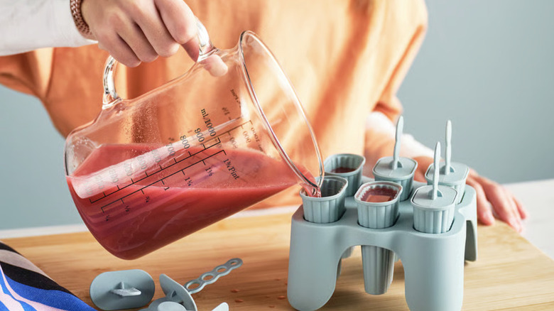 Person filling up an IKEA UPPFYLLD ice pop maker