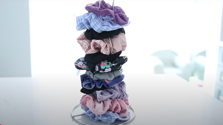 Scrunchies stacked on a paper towel holder.