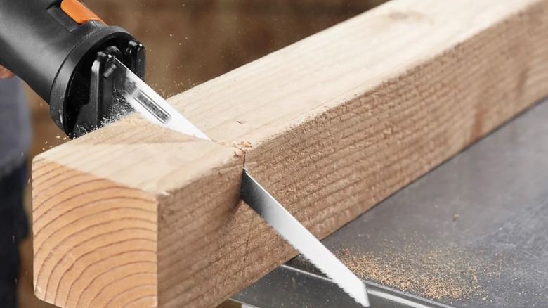 Person cutting wood with a reciprocating saw