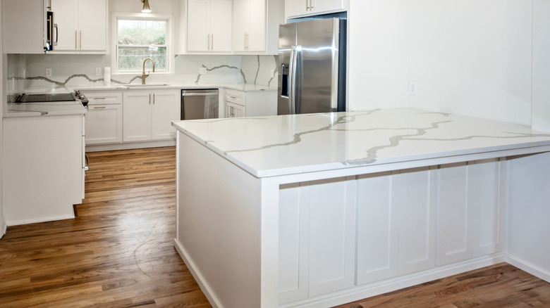 White quartz countertops in a bright white kitchen