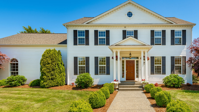 A modern colonial home with a red door