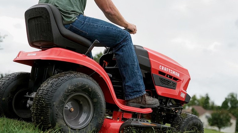 A man riding a CRAFTSMAN T110 Lawn Mower & Tractor