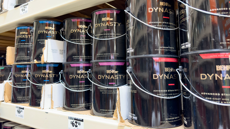 Behr Dynasty paint cans on a store shelf.