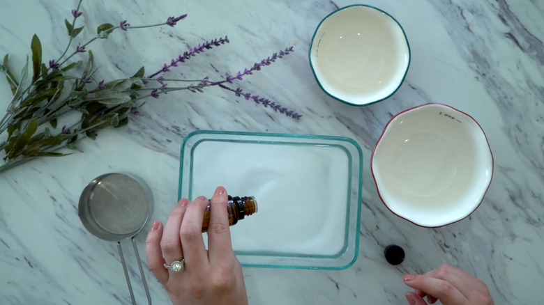 Person putting lavender essential oil in a DIY laundry additive