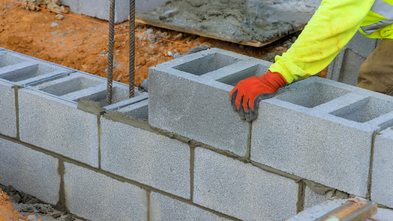 A professional is using concrete blocks in the construction of a building