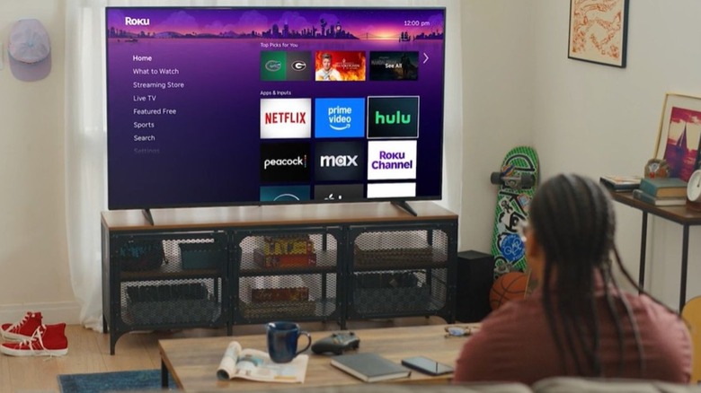 Individual using a Roku streaming stick on a large flat screen TV