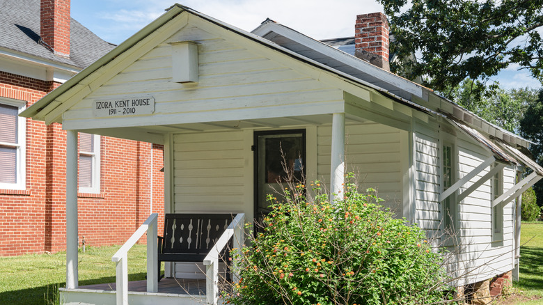 A white shotgun house with gray trim